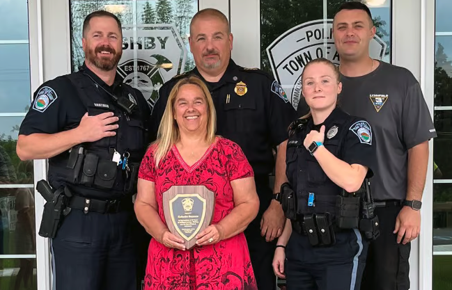From left, Acting Sgt. Brian Vautour, retiring Administrative Assistant to the Police Chief Katherine Bezanson, Acting Police Chief Derek Pepple, Officer Alexandra Hecker, and Officer Christopher Davis, outside the Ashby Police Station. 